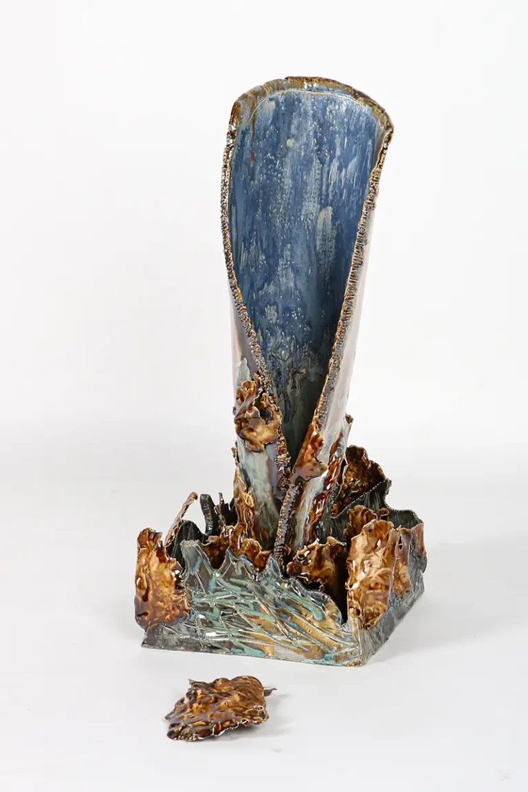 Scultura ceramica a forma di C con foglie dorate, ispirata al vento e al movimento autunnale