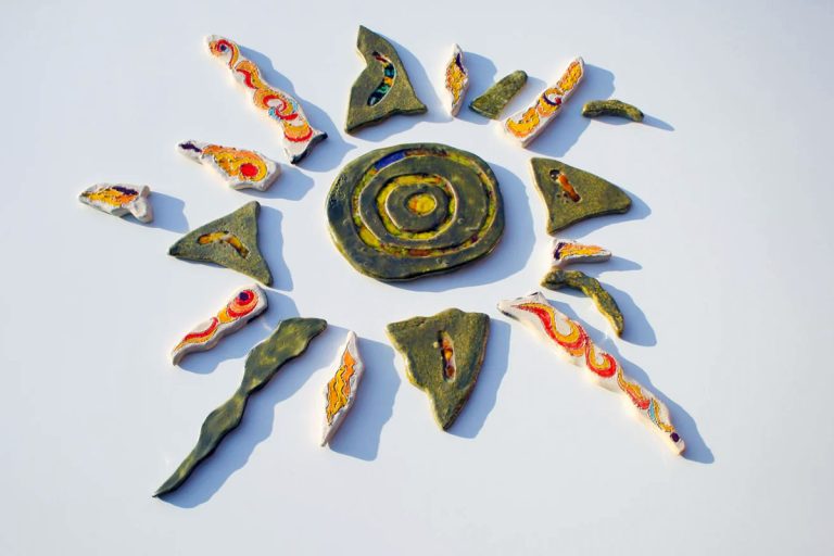 Scultura ceramica di grande formato in argilla bianca con fulcro centrale a effetto lustro, vetri fusi e raggi multicolore brillanti