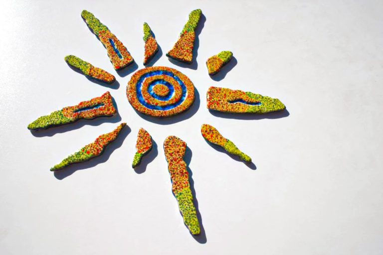 Scultura ceramica di medio formato con decorazione a puntini rossi e verdi, fulcro centrale con inserti in vetro fuso blu e azzurro