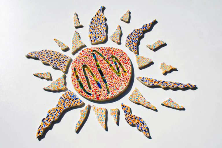 Scultura ceramica di medio formato con tocchi di pennello multicolore, fulcro rosso-arancio e dettagli in vetro fuso