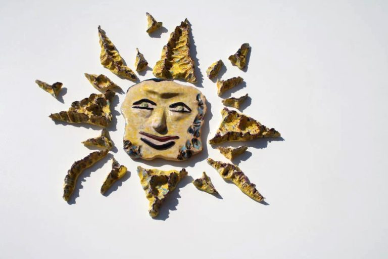 Sole in ceramica di medio formato smaltato in giallo tenue e delicato, con piccoli tocchi di colore e dettagli materici sottili.