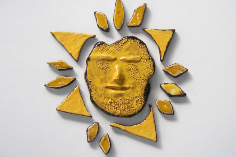 Sole monocromatico smaltato in un giallo ad effetto con raggiera asimmetrica e nucleo sferico forgiato a mano.