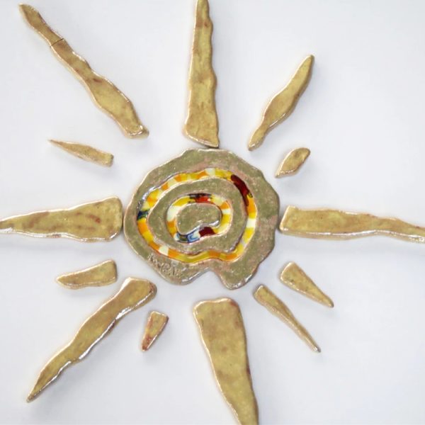 Sole in ceramica con fulcro a spirale arricchito da vetri fusi e raggi lunghi e sottili in smalti chiari opalescenti.