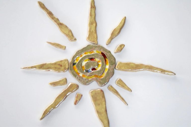 Sole in ceramica con fulcro a spirale arricchito da vetri fusi e raggi lunghi e sottili in smalti chiari opalescenti.