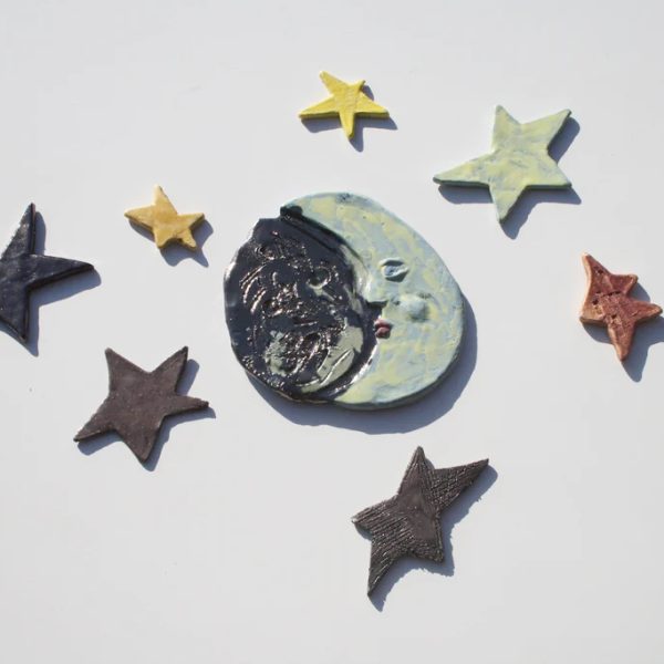 Luna media in ceramica azzurra caratterizzata da un profilo nero ad effetto e un lato giallo chiaro, con stelle.