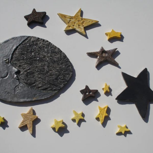 Grande luna bicolore in ceramica che unisce un profilo nero a una semiluna argento, circondata da stelle.