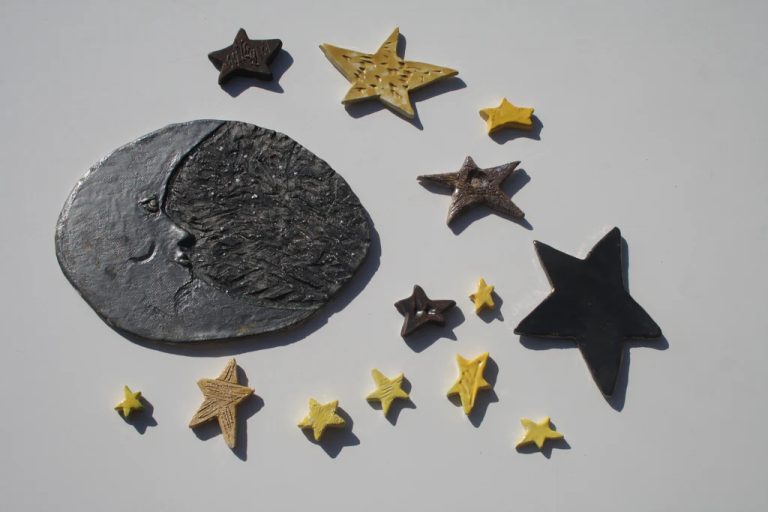 Grande luna bicolore in ceramica che unisce un profilo nero a una semiluna argento, circondata da stelle.