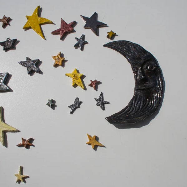 Luna crescente in argilla nera con profondi solchi scultorei e velatura di cristallina lucida, circondata da stelle.