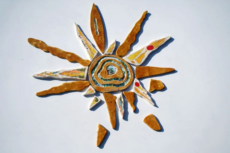 Grande sole in argilla bianca con profondo fulcro vibrante miele e vetro fuso, e raggi rifiniti con velatura di cristallina trasparente.