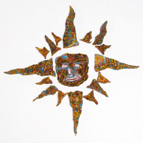 Sole medio a rosa dei venti su refrattario marrone con maschera centrale sorridente e raggi in smalti giallo, azzurro e celeste.
