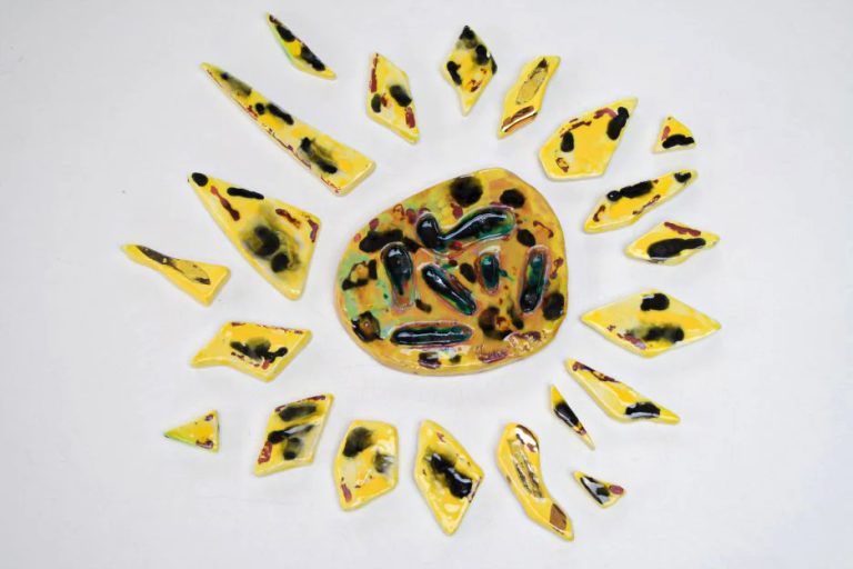 Sole medio in argilla bianca con dettagli neri e cristallina verde nel fulcro, impreziosito da pennellate di lustro d'oro.