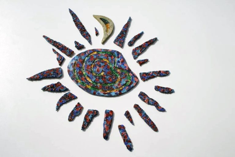 Grande sole scultoreo con graffi grafici in smalto rosso e blu, con una stella filante in vetro fuso nel fulcro.